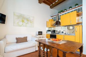eine Küche und ein Wohnzimmer mit einem Tisch und einem Sofa in der Unterkunft Uffizi Place in Florenz
