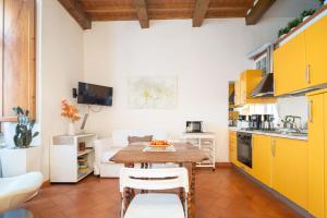 eine Küche und ein Wohnzimmer mit einem Holztisch und gelben Schränken in der Unterkunft Uffizi Place in Florenz