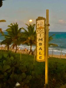 un cartel en un poste frente a la playa en Casa ImBale en Imbassai