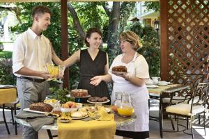 a group of people standing around a table with food at Relais Fenicottero Rosa in Porto San Paolo