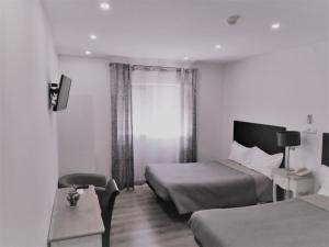 a hotel room with two beds and a window at Hotel Domus in Coimbra