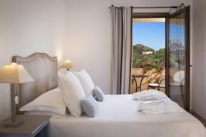 a bedroom with a bed with a view of a balcony at Relais Fenicottero Rosa in Porto San Paolo