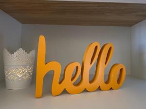 a sign with the word hello next to a vase at Luz Beach Apartments in Luz