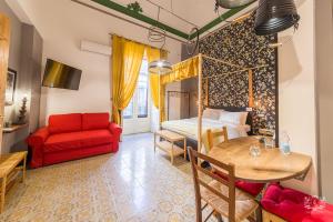 a living room with a red couch and a table at Grand Tour Design Guest House Catania Self Check-in in Catania