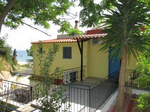 Iliotropio Ligia في ليغيا: منزل أصفر مع شرفة بجوار المحيط