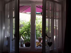 uma janela aberta com um urso de peluche a olhar para fora em Au soleil de Gruyères chez Chantal em Gruyères