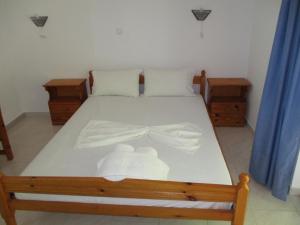 Un dormitorio con una cama con una pajarita. en Iliotropio Ligia en Lygiá