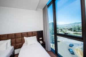 um quarto de hotel com duas camas e uma grande janela em Hotel Shine Palace em Tbilisi