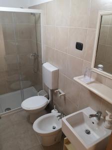 e bagno con servizi igienici, lavandino e doccia. di B&B Corte San Giuseppe a Casarano