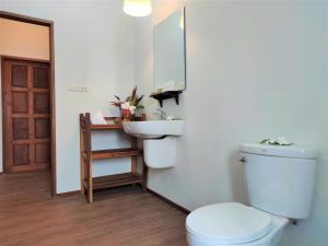 a bathroom with a toilet and a sink and a mirror at Armonia Village Resort and Spa in Chumphon