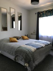 1 dormitorio con cama con almohadas y ventana en Relais de la poste, en Monclar-de-Quercy