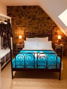 1 dormitorio con 1 cama con pared de ladrillo en Trevejean chambre d'hotes de charme, en Guerlédan