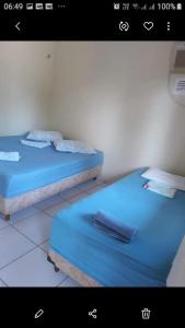 two beds in a room with blue sheets at Pousada Sossego Salinas in Salinópolis +37 photos