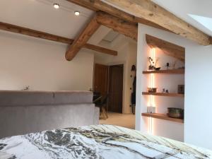 sypialnia z łóżkiem i drewnianymi belkami stropowymi w obiekcie The Bijoux - Dolomites w mieście Agordo