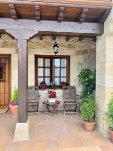 a patio with two benches and a table and a window at Posada San Pedro in Oreña