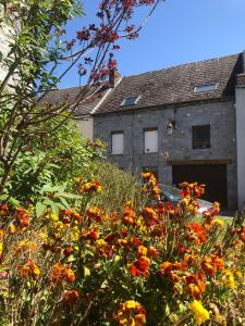 a garden with flowers in front of a building at chez Suzanne in Chooz