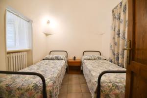 dwa łóżka pojedyncze w pokoju z oknem w obiekcie Agriturismo il Ciliegeto w mieście Locorotondo