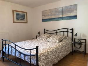 een slaapkamer met een bed en twee foto's aan de muur bij chez Suzanne in Chooz