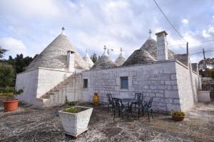 budynek z krzesłami i stołem przed nim w obiekcie Agriturismo il Ciliegeto w mieście Locorotondo