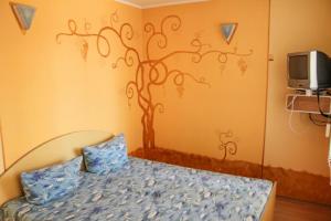 a bedroom with a bed with a tree mural on the wall at Guest House 1279 in Zatoka