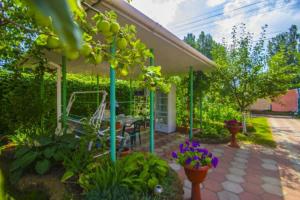 a house with a porch with a bench and flowers at Guest House 1279 in Zatoka