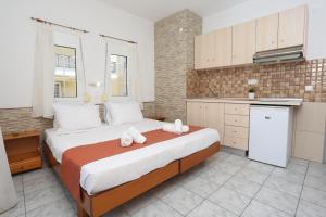 a bedroom with a large bed and a kitchen at Villa Magda Maria in Pefkohori