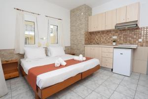 a bedroom with a large bed and a kitchen at Villa Magda Maria in Pefkochori