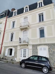 a black car parked in front of a building at Les pieds dans l'eau in Trouville-sur-Mer