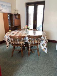 una mesa de comedor con 2 sillas y una mesa con flores. en Quayside Close Holiday Apartments, en Poole