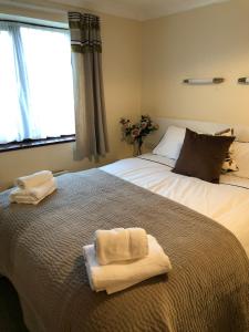 プールにあるQuayside Close Holiday Apartmentsのタオルが敷かれた大きなベッドのある寝室