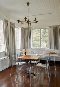 a dining room with tables and chairs and windows at Blind Tiger Portland - Danforth Street in Portland