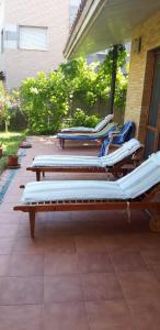 - une rangée de chaises longues assises sur une terrasse dans l'établissement VIVIENDA TURÍSTICA LOS OLIVOS, à Fontellas