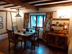 uma sala de jantar com uma mesa, cadeiras e um espelho em Witherhill Granary em High Bickington