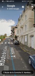 a street with a car parked on the road at Les pieds dans l'eau in Trouville-sur-Mer