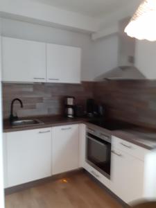 cocina con armarios blancos y fogones en Ferienwohnung Busdorf, en Busdorf