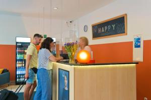 a group of people standing around a counter in a store at Happy Hotel Berlin in Berlin