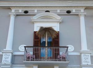 a white building with a balcony with an umbrella at DON GIL CHIC in Polignano a Mare