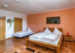 una camera da letto con un letto con cuscini bianchi di Pension zum Reiterhof a Schmogrow