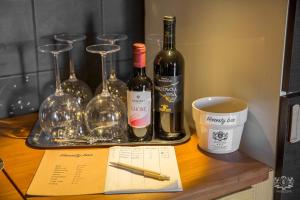 a table with wine bottles and glasses on it at Grand Tour Design Guest House Catania Self Check-in in Catania