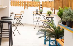 a patio area with chairs, tables and umbrellas at Casa Grande Surf Hostel in El Médano