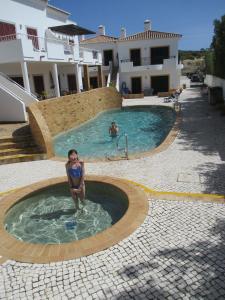 een vrouw zit in een zwembad bij Casa Carmela in Burgau