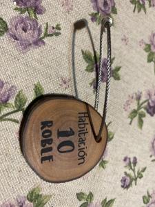 a small wooden medal on a cloth with flowers at Hotel Rural Los Texos in La Riera