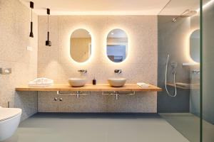 a bathroom with two sinks and two mirrors at Ribarska Koliba Resort in Pula
