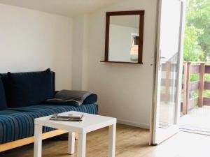 a living room with a couch and a table at Ferienwohnung Eiderblick in Hennstedt +4 photos