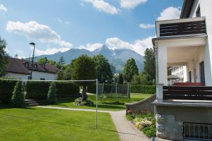 a view of a yard with mountains in the background at Vila Mala Marta in Vysoke Tatry - Tatranska Lomnica.
