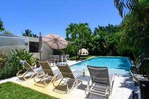 um grupo de cadeiras e uma piscina em Paradise Home 3 BR with Heated Pool close to Beach em Fort Lauderdale