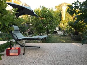 拉布的住宿－一號公寓，花园内带遮阳伞的椅子