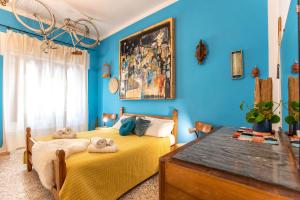 Boipeba Guesthouse في ألغيرو: سريرين في غرفة بجدران زرقاء