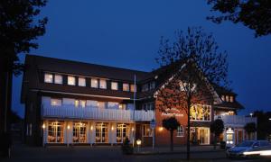 ein Gebäude mit nachts eingeschaltetem Licht in der Unterkunft Hotel-Restaurant Ammertmann in Gronau
