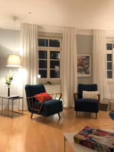 ein Wohnzimmer mit 2 Stühlen und einem Sofa in der Unterkunft Zentraler geht es kaum - in königlicher Nachbarschaft! in Ludwigsburg